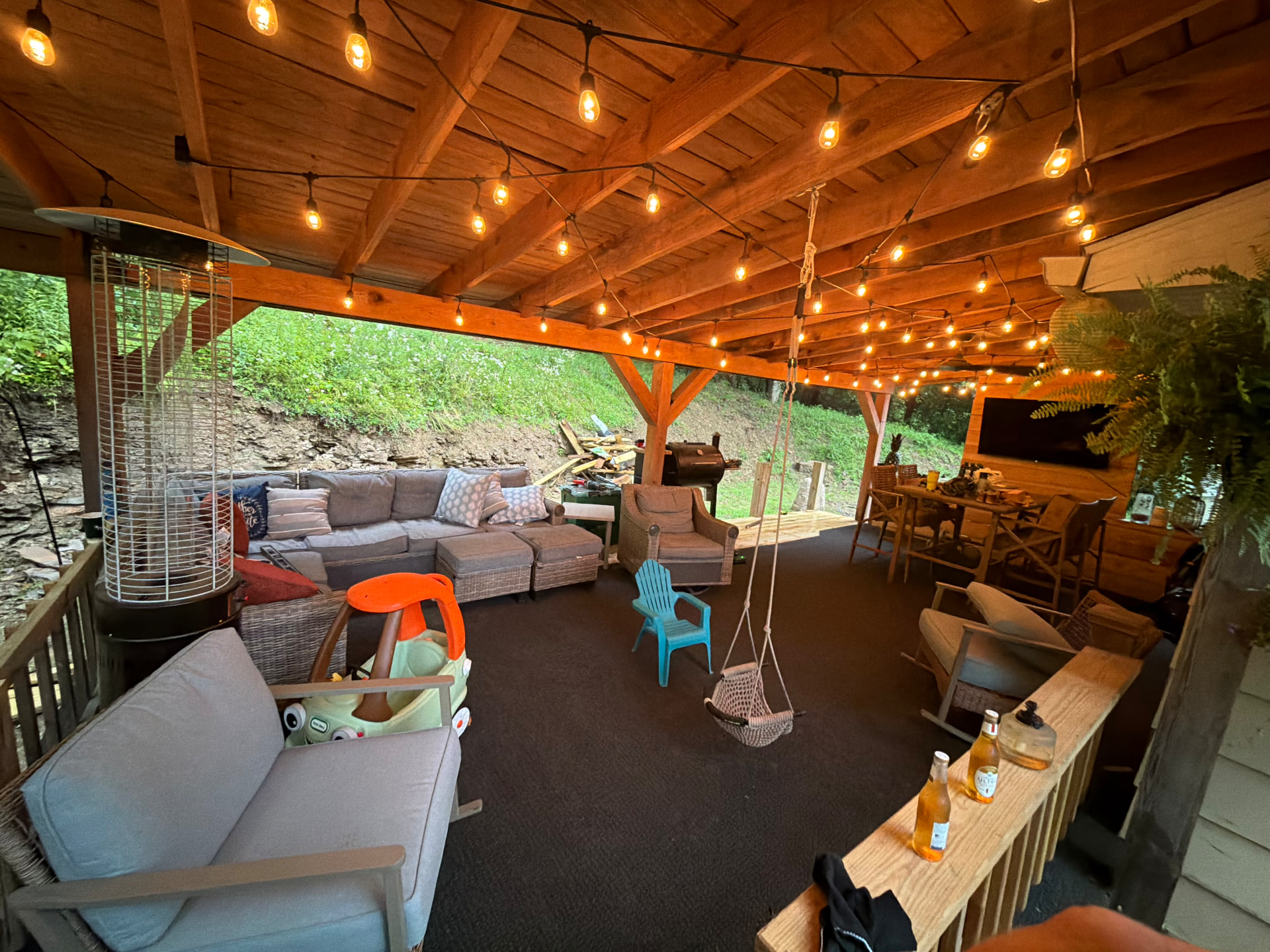 Covered outdoor patio pavilion with exposed rafters and string lights