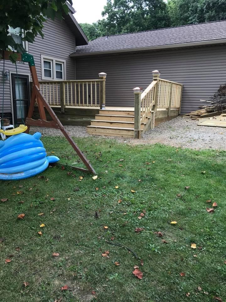 Rear deck with new wood railing, post caps and wide entry steps