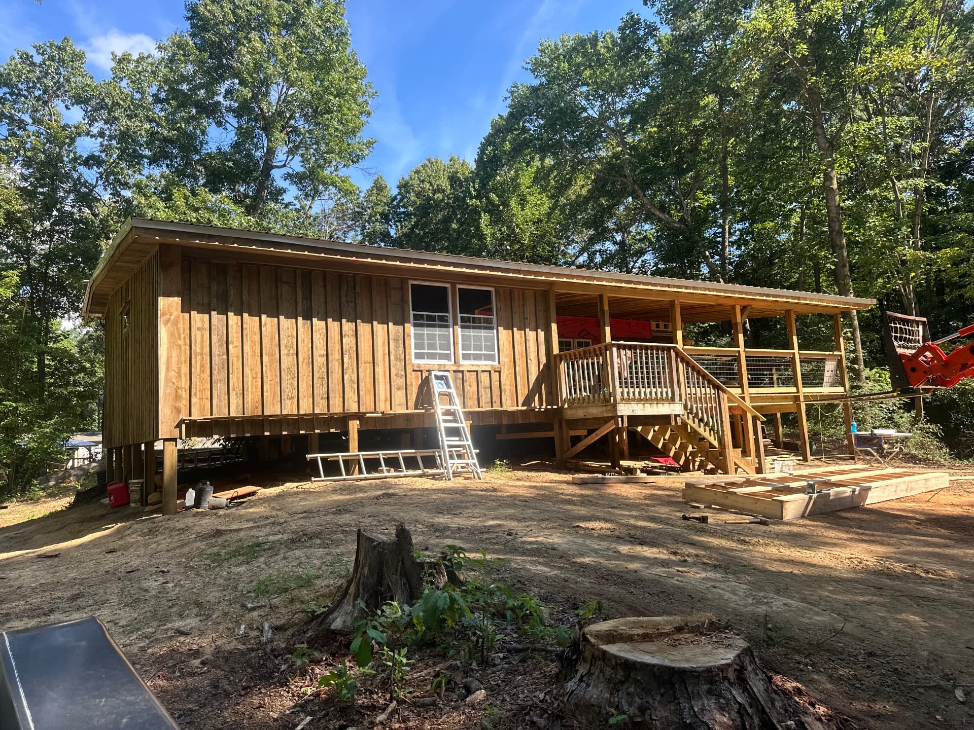 New rough-sawn board and batten cabin with covered porch and stairs