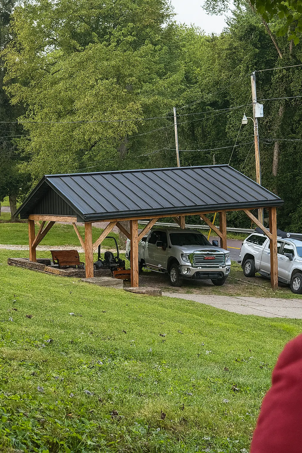 Timber post-and-beam carport with black standing seam metal roof