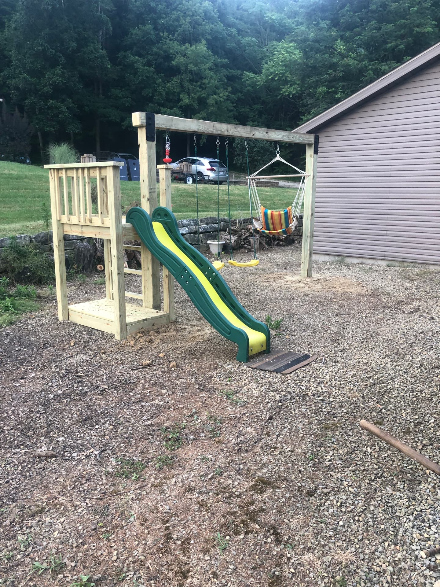 Custom-built wooden swing set and playset with slide and platform